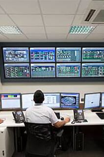 Three security officers monitoring cctv footage in a room