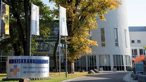 Exterior of a hospital building with a signboard