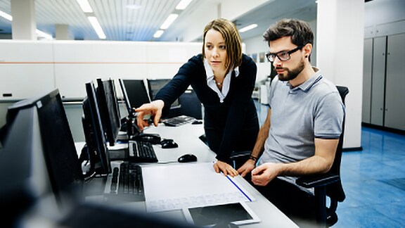 Man and woman discussing looking at the laptop